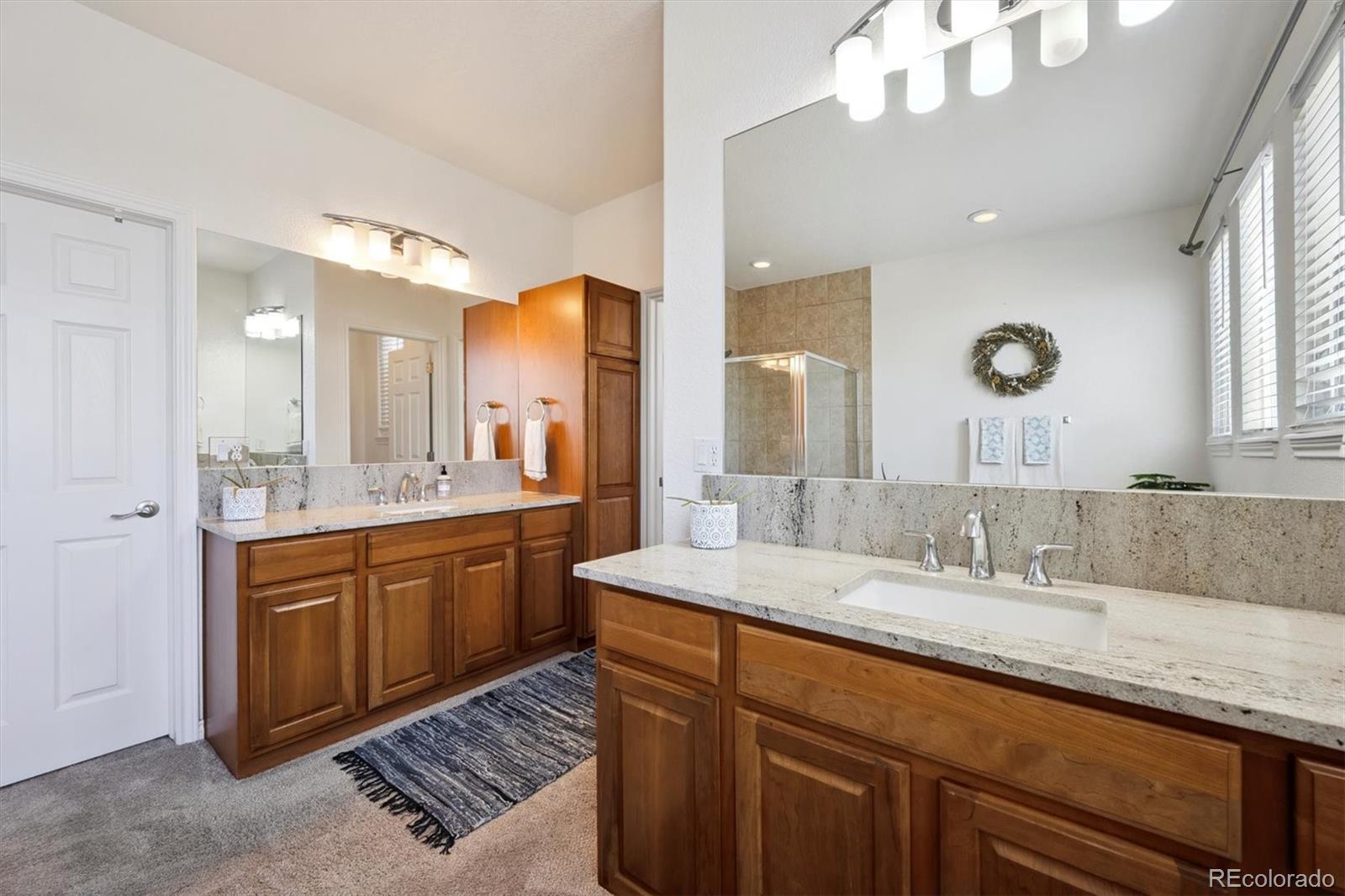 724 Imboden Road Watkins, CO 80137 - Photo 20 of 50 a bathroom with a granite countertop double vanity sink and a mirror