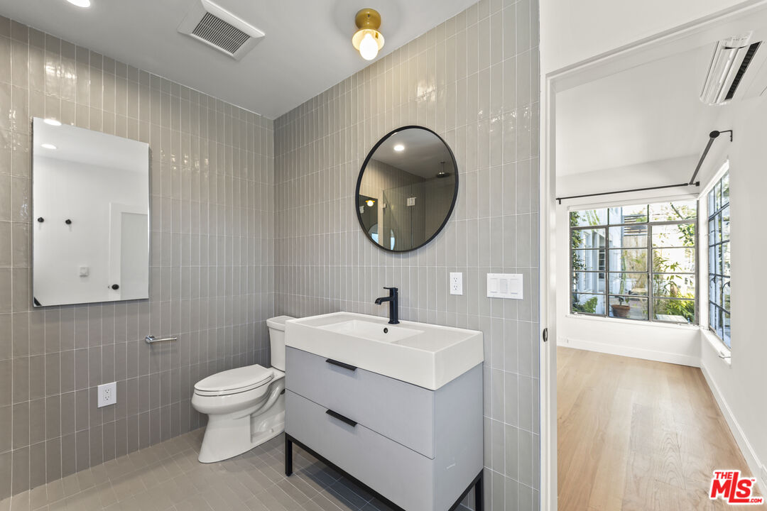 751 18th Street, Unit B Santa Monica, CA 90403 - Photo 16 of 24 a bathroom with a toilet a sink and mirror