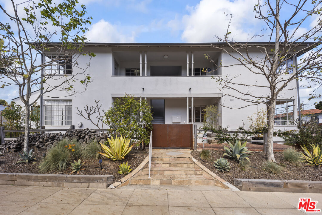 751 18th Street, Unit B Santa Monica, CA 90403 - Photo 19 of 24 a view of a white building with large windows and a table and chairs