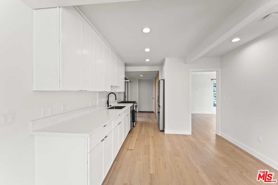 751 18th Street, Unit B Santa Monica, CA 90403 - Photo 8 of 24 a large kitchen with a lot of counter space and wooden floor