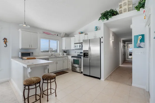 a kitchen with white cabinets and sink
