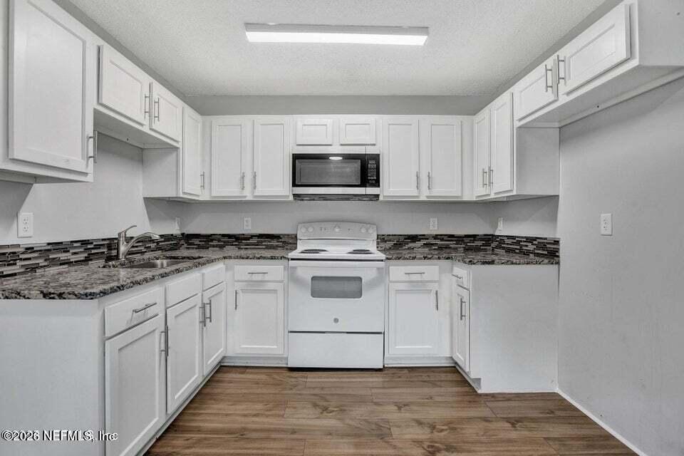3645 Edison Avenue Jacksonville, FL 32254 - Photo 7 of 21 a white kitchen with granite countertop white cabinets a sink and dishwasher