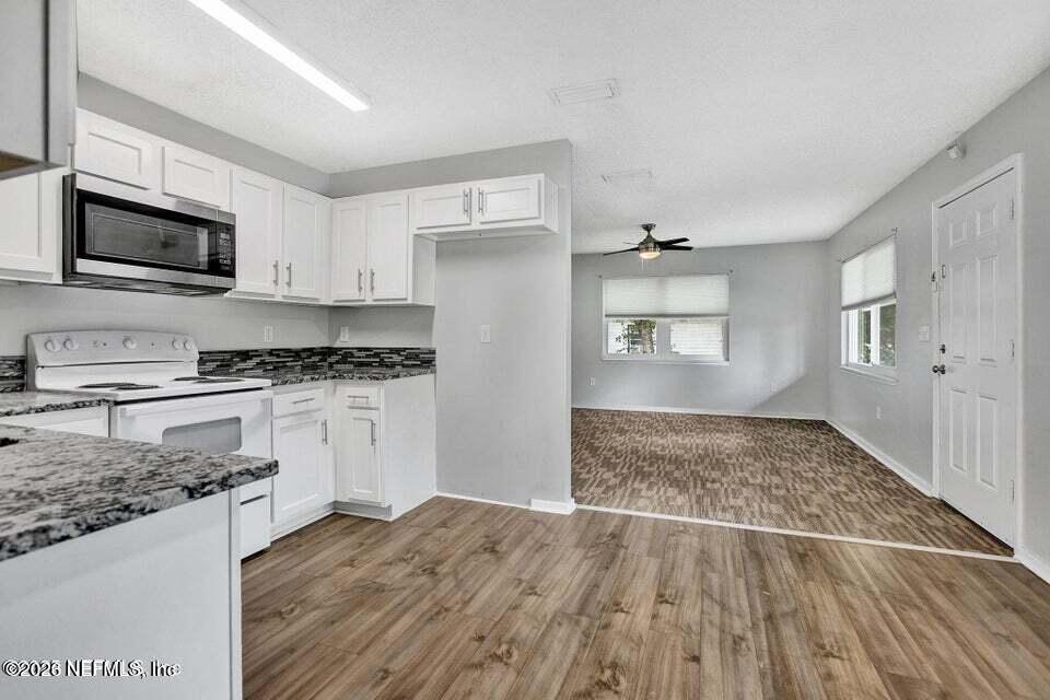 3645 Edison Avenue Jacksonville, FL 32254 - Photo 8 of 21 a kitchen with granite countertop a stove top oven a sink dishwasher and a refrigerator with wooden floor
