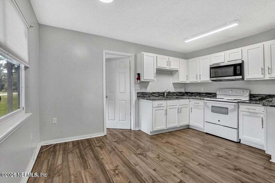 3645 Edison Avenue Jacksonville, FL 32254 - Photo 9 of 21 a kitchen with granite countertop white cabinets and white appliances