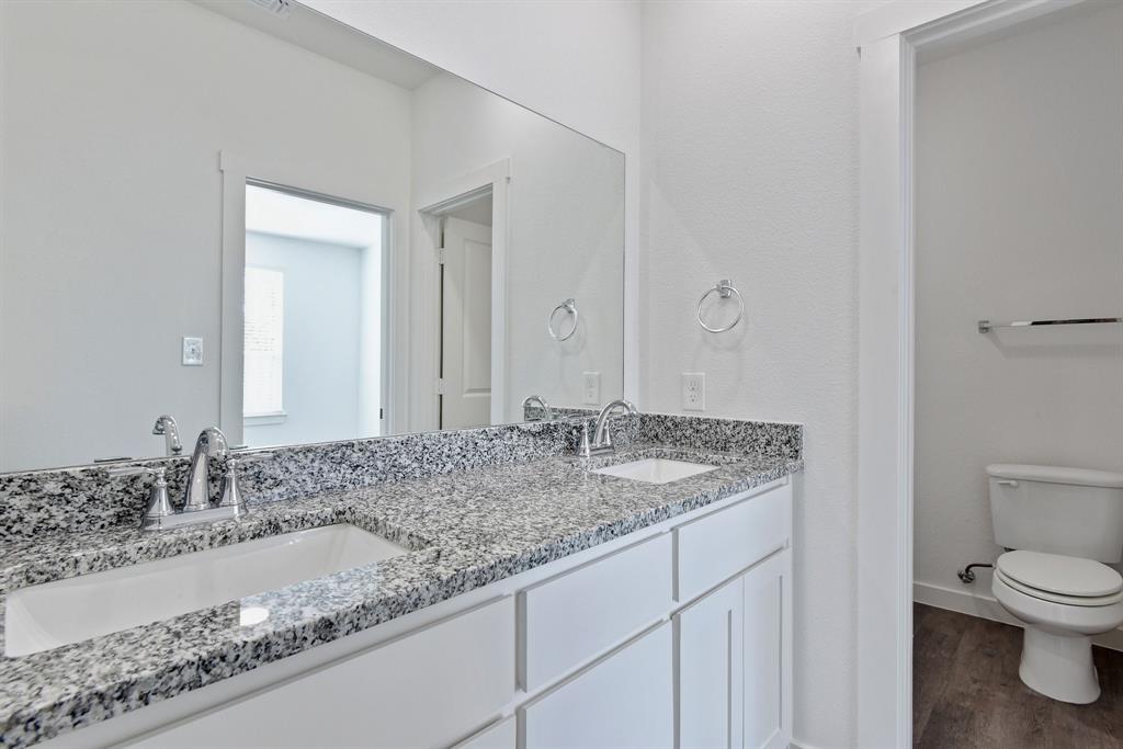 718 West Texas Street Denison, TX 75020 - Photo 17 of 22 a bathroom with a granite countertop sink and a mirror