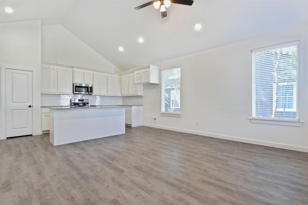 718 West Texas Street Denison, TX 75020 - Photo 4 of 22 a kitchen with stainless steel appliances granite countertop a stove top oven a sink dishwasher and a refrigerator with wooden floor