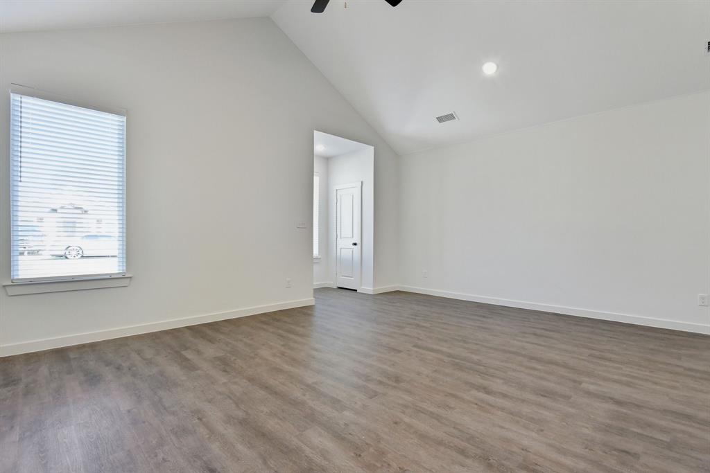 718 West Texas Street Denison, TX 75020 - Photo 5 of 22 a view of an empty room with wooden floor and a window