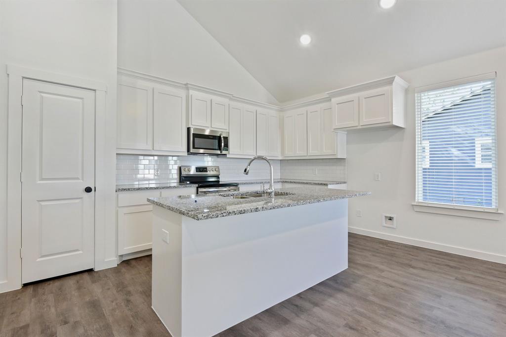 718 West Texas Street Denison, TX 75020 - Photo 7 of 22 a kitchen with stainless steel appliances granite countertop a sink a stove a refrigerator a microwave and cabinets