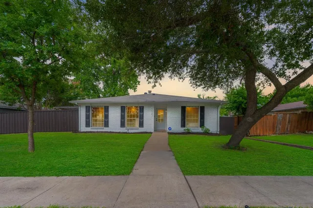 a front view of a house with yard and green space