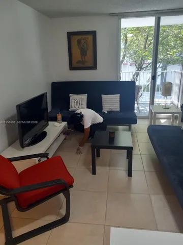 a living room with furniture and a floor to ceiling window