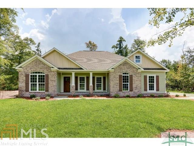 263 Zittrouer Road, Unit 4 Guyton, GA 31312 - Photo 1 of 1 a front view of a house with a garden and trees
