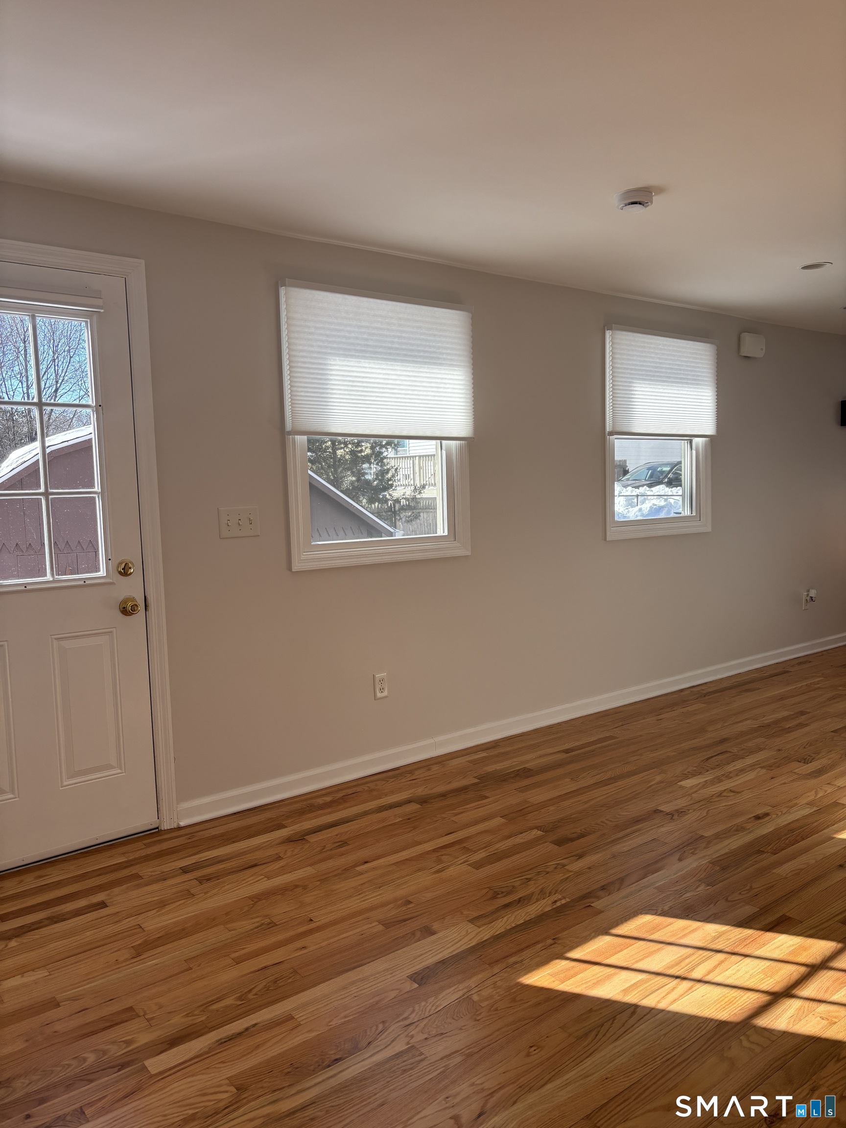 98 Ridgewood Avenue, Unit COTTAGE Stamford, CT 06907 - Photo 5 of 10 a view of an empty room with wooden floor and a window
