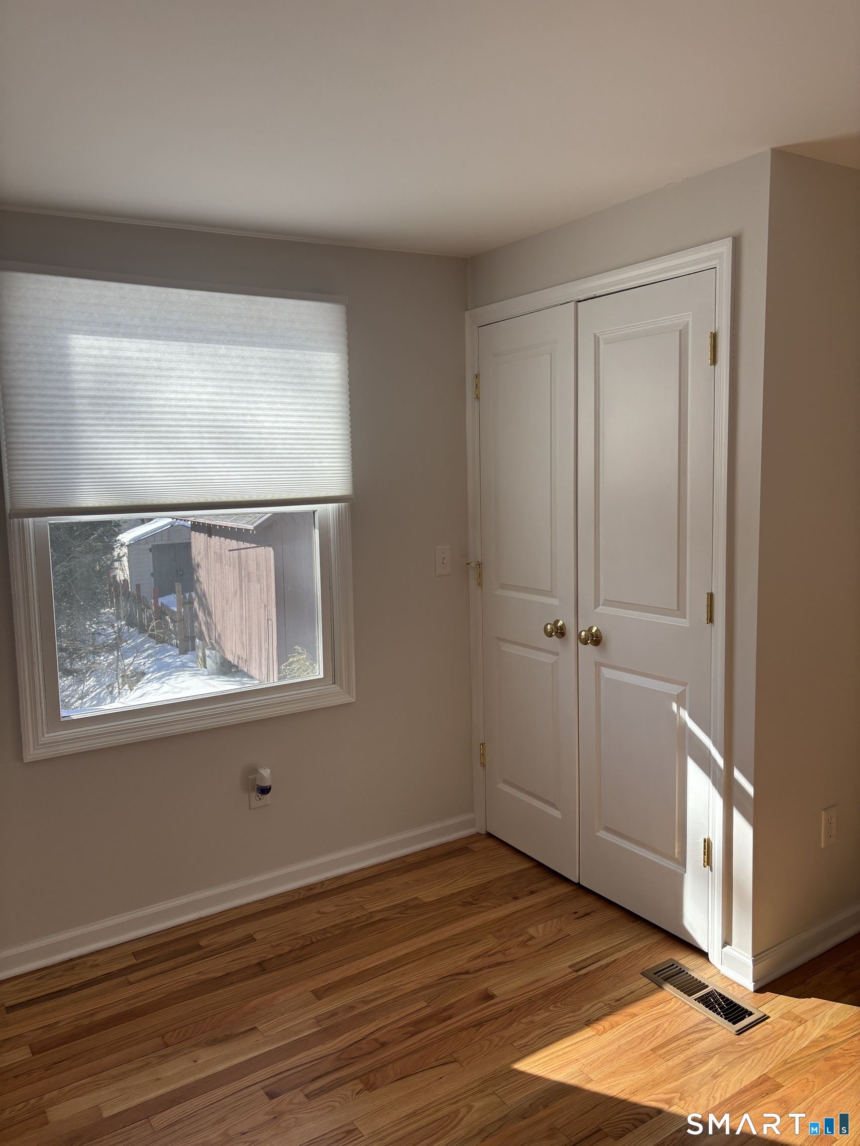 98 Ridgewood Avenue, Unit COTTAGE Stamford, CT 06907 - Photo 8 of 10 a view of an empty room with wooden floor and a window