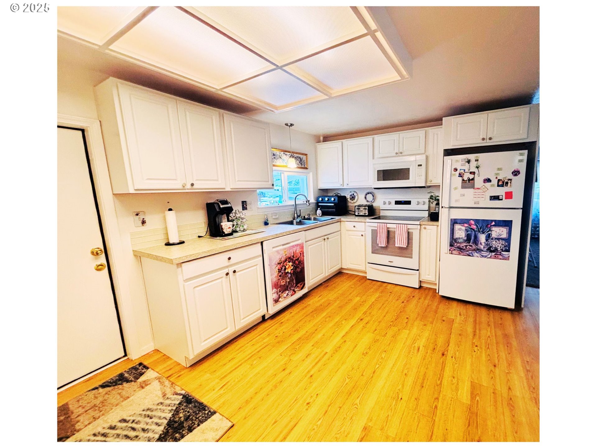1125 58th Street, Unit 86 Springfield, OR 97478 - Photo 8 of 44 a kitchen with stainless steel appliances a stove a sink dishwasher a refrigerator white cabinets with wooden floor
