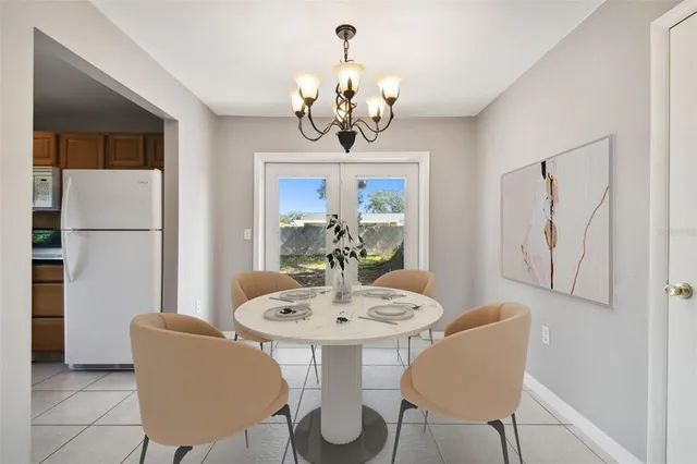 an empty room with wooden floor chandelier fan and windows