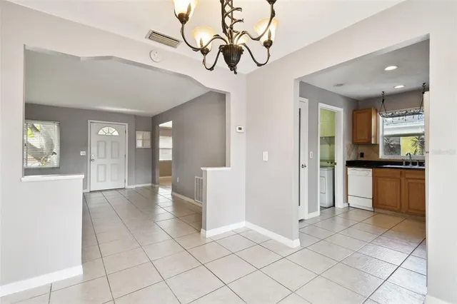 an empty room with wooden floor closet and windows
