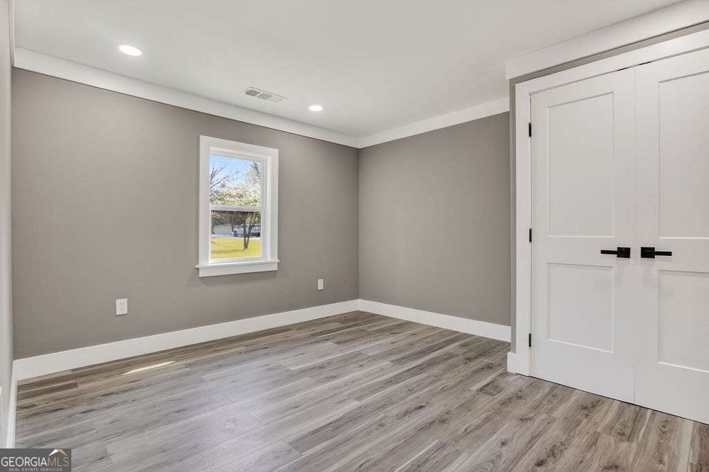 206 Walker Drive Monroe, GA 30655 - Photo 18 of 32 wooden floor in an empty room with a window