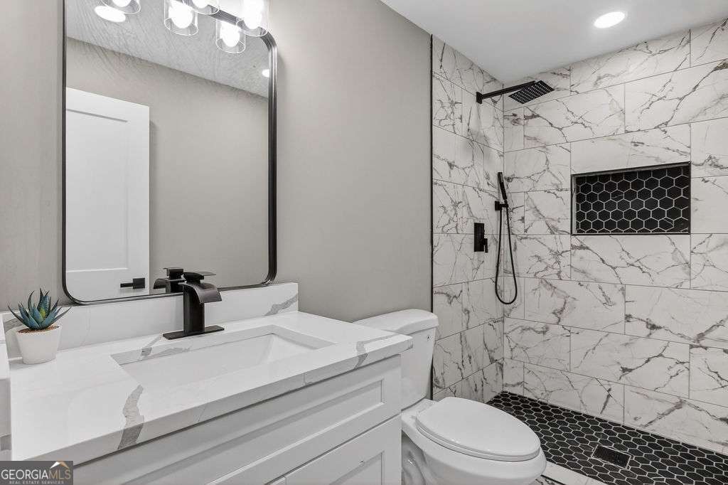 206 Walker Drive Monroe, GA 30655 - Photo 19 of 32 a bathroom with a sink toilet a mirror and shower