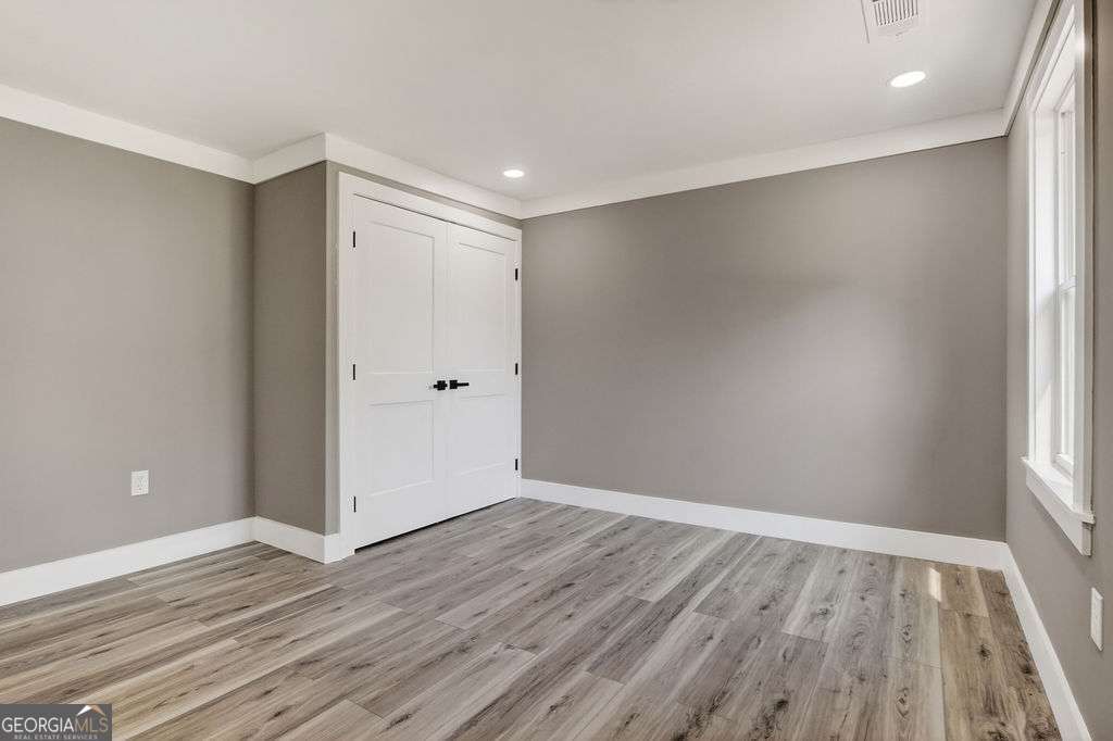 206 Walker Drive Monroe, GA 30655 - Photo 23 of 32 a view of an empty room with wooden floor and a window