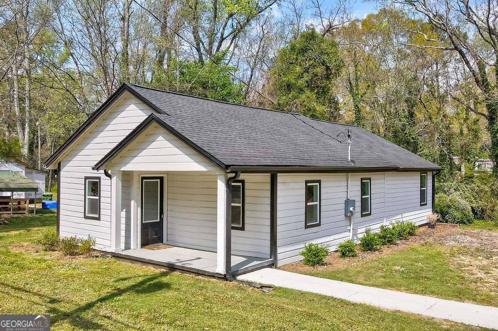 206 Walker Drive Monroe, GA 30655 - Photo 26 of 32 a front view of house with yard and trees in the background