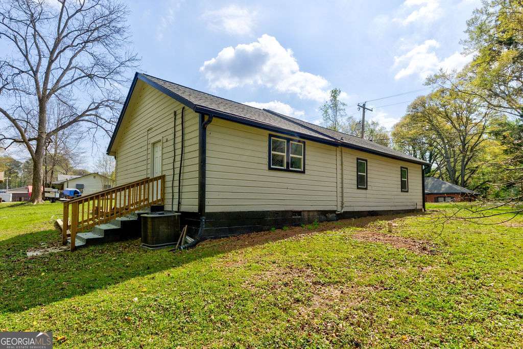 206 Walker Drive Monroe, GA 30655 - Photo 28 of 32 a backyard of a house with wooden fence and large trees