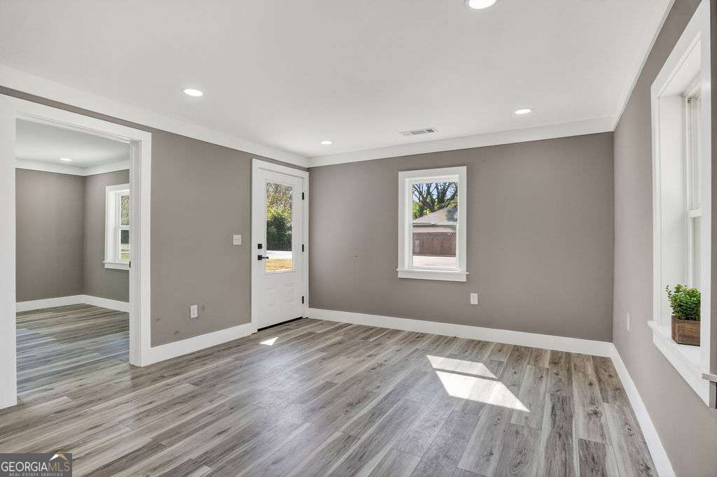 206 Walker Drive Monroe, GA 30655 - Photo 5 of 32 an empty room with wooden floor and windows
