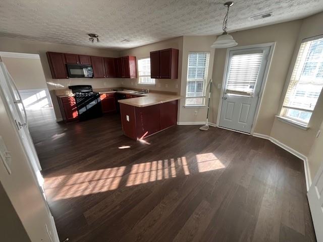 303 Millstone Drive Hampton, GA 30228 - Photo 7 of 16 a kitchen with stainless steel appliances granite countertop a stove a sink dishwasher and a microwave oven with wooden floor