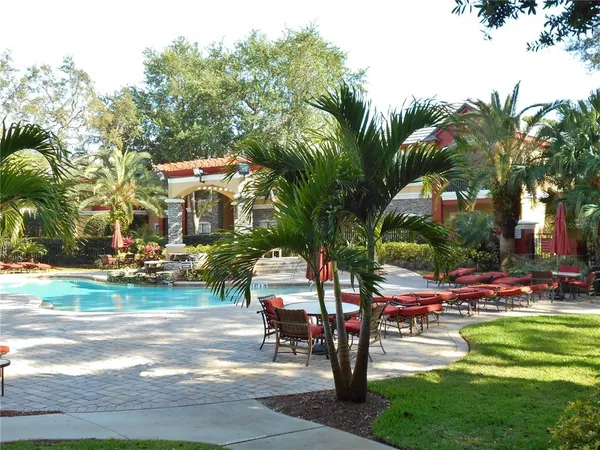 a row of palm trees sitting in a yard with swimming pool