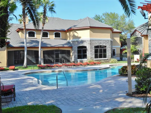 a front view of a house with swimming pool and a table and chairs