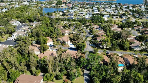 an aerial view of lake residential house with swimming pool and outdoor seating