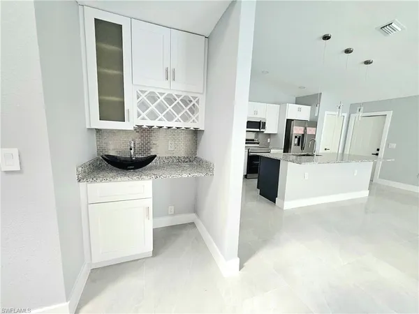 a kitchen with stainless steel appliances kitchen island granite countertop a refrigerator and a stove top oven
