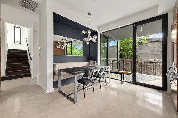 a dining room with furniture and a floor to ceiling window
