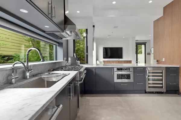 a kitchen with stainless steel appliances granite countertop a sink a stove and a refrigerator