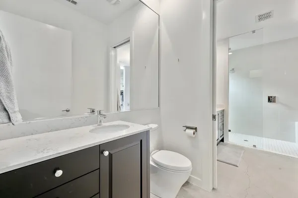 a bathroom with a sink a toilet and shower