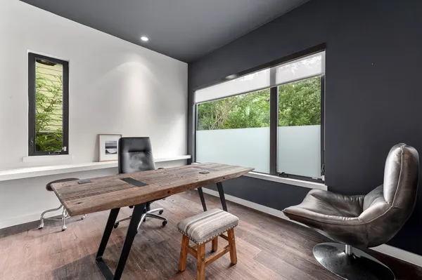 a view of a workspace with furniture and a window