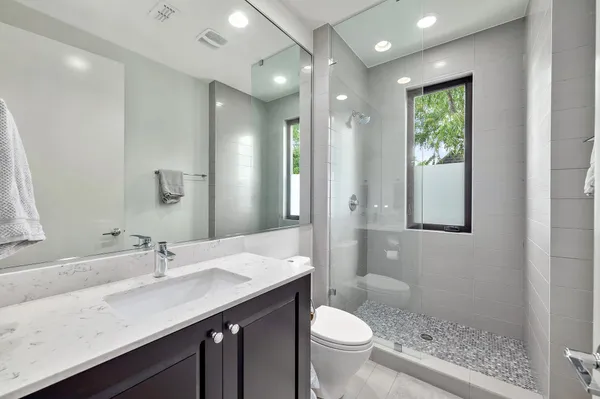 a bathroom with a granite countertop sink toilet and shower