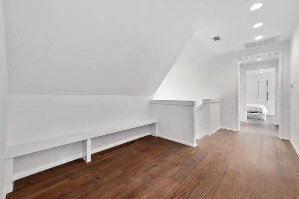 a view of empty room with wooden floor and window