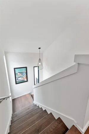 a view of a bedroom with wooden floor and hallway