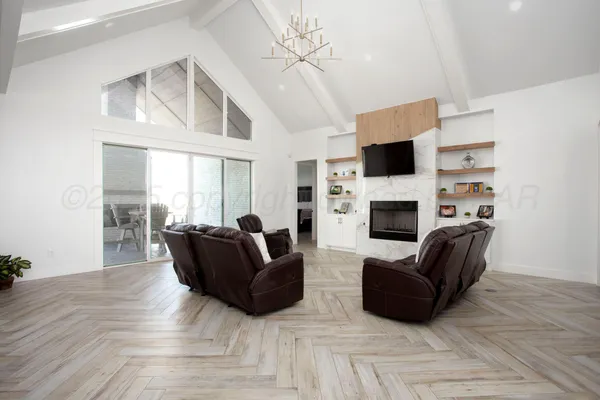 a living room with furniture a flat screen tv and a fireplace