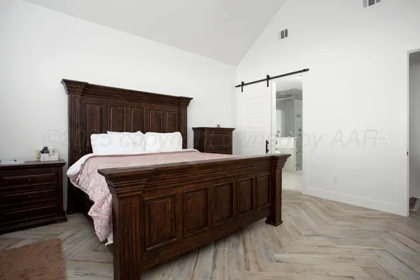 a bedroom with a bed and wooden floor