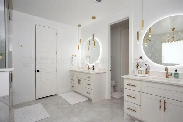 a en suite bathroom with a double vanity sink and a mirror