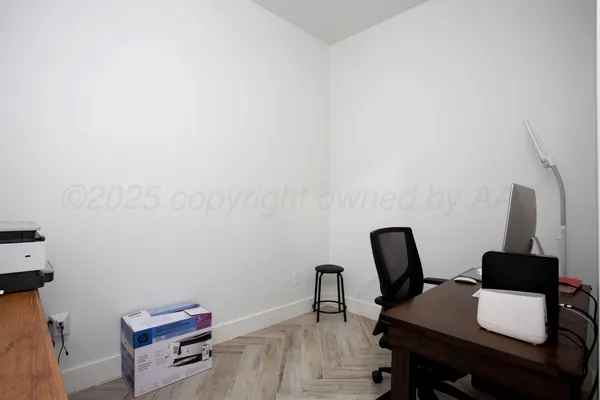 a view of a workspace with furniture and wooden floor