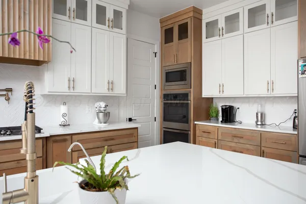 a kitchen with stainless steel appliances a white refrigerator a sink a stove and white cabinets