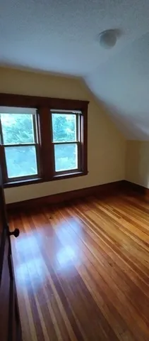 en empty room with wooden floor and windows