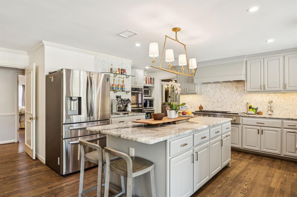 4549 Walnut Hill Lane Dallas, TX 75229 - Photo 14 of 40 a kitchen with stainless steel appliances a stove a sink dishwasher a refrigerator and cabinets with wooden floor