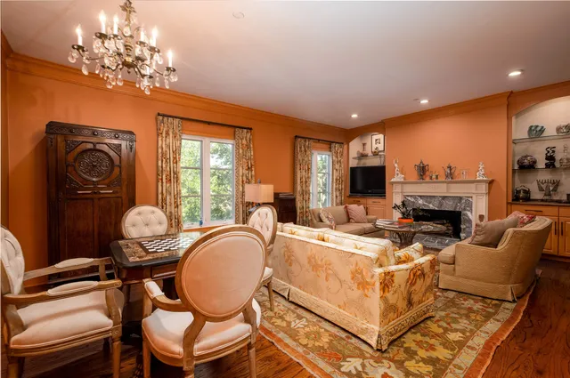 a living room with furniture a fireplace and a chandelier