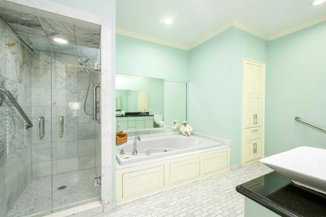 a bathroom with a tub sink shower and mirror