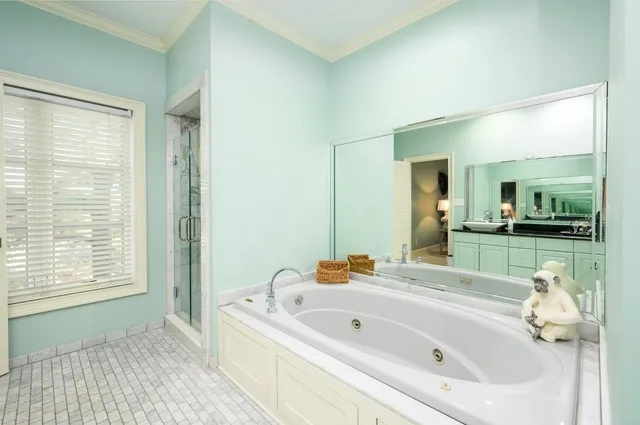 a bathroom with a tub a sink and a large mirror