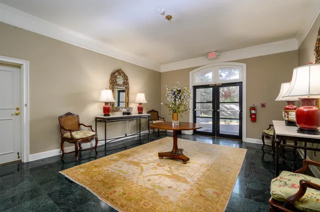 a living room with furniture a chandelier and a dining table with wooden floor