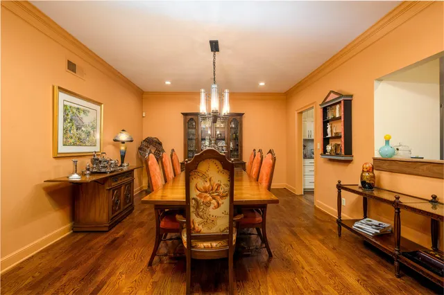 a dining room with furniture a chandelier and wooden floor